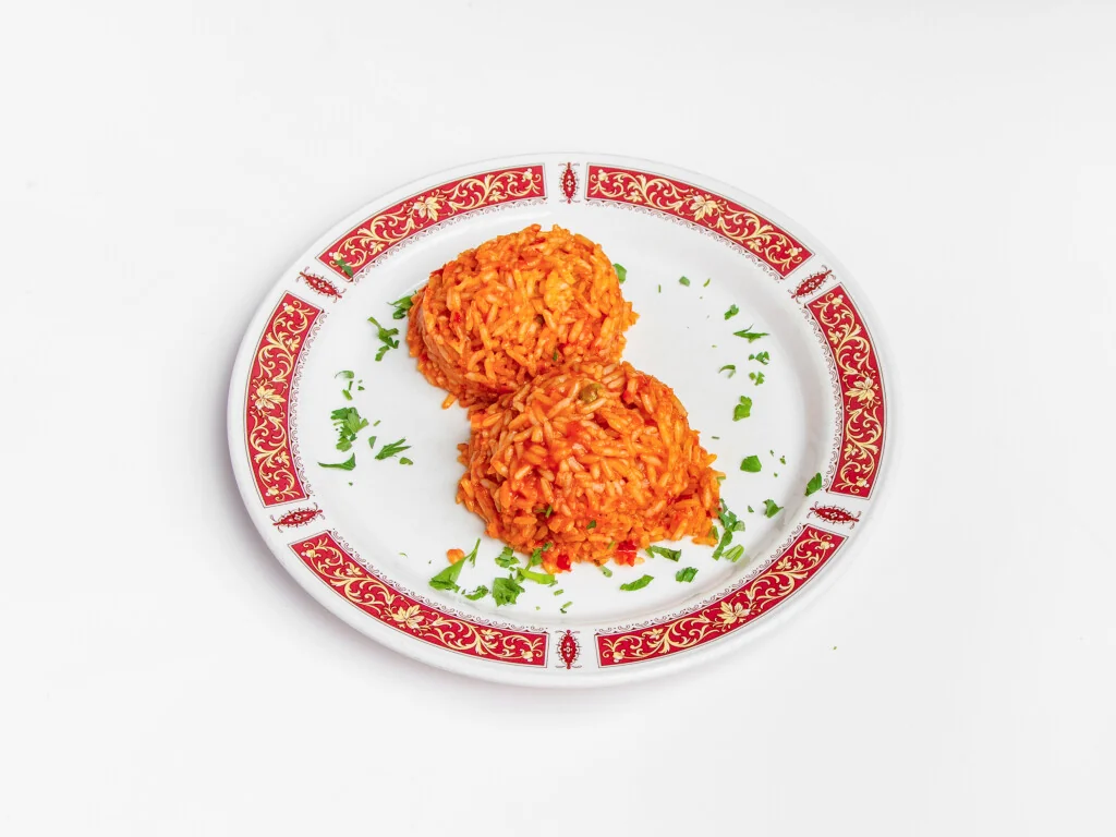 Zwei Portionen Djuvec-Reis auf einem Teller mit rot-goldenem Dekor
