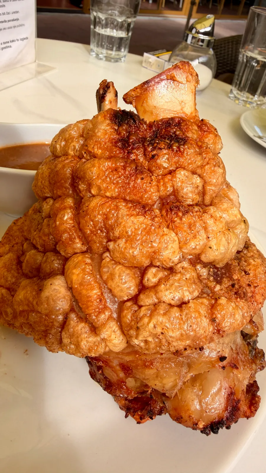 Nahaufnahme der krossen Kruste einer servierten Schweinshaxe in der Adlermühle